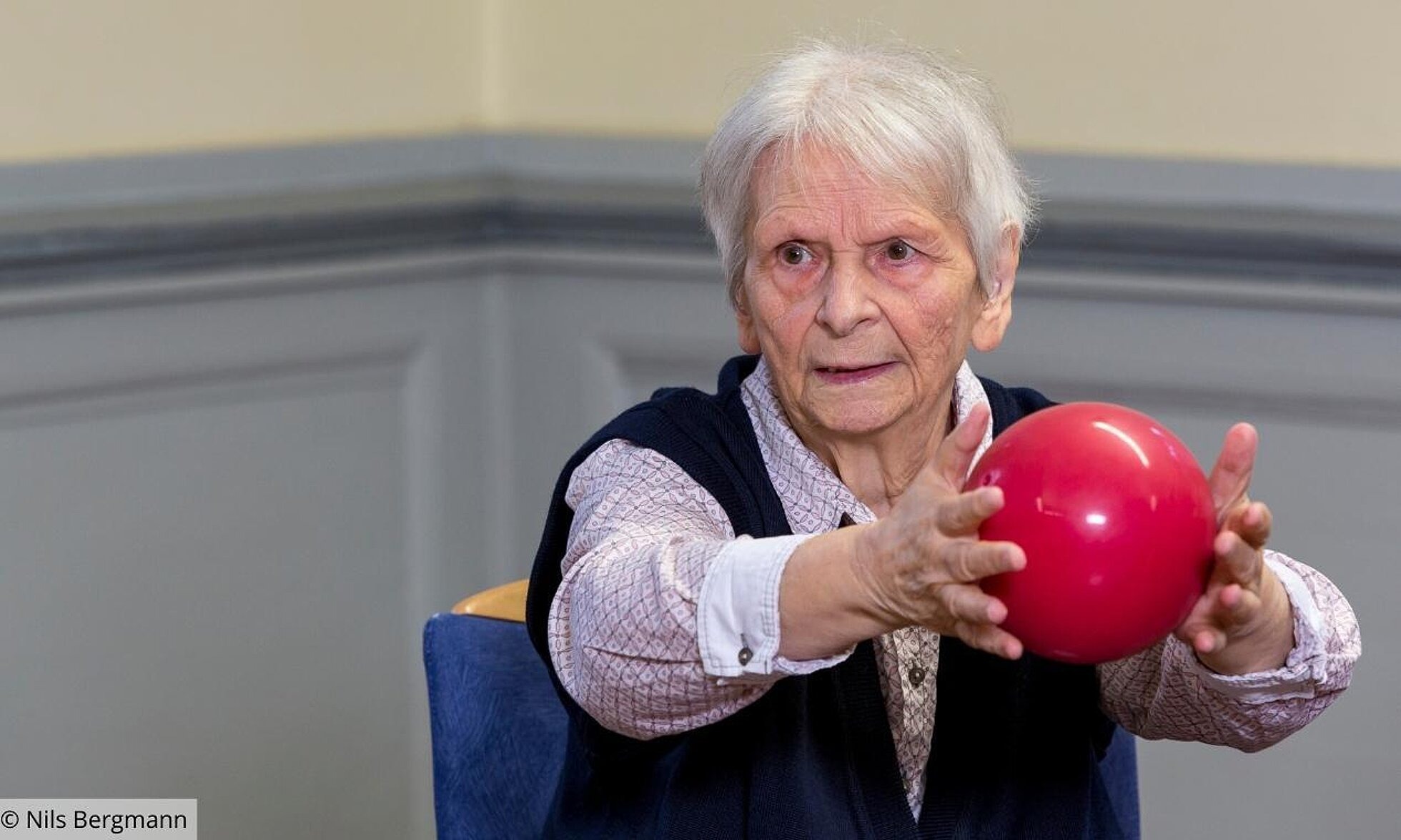 ältere Frau mit Ball zwischen den Händen
