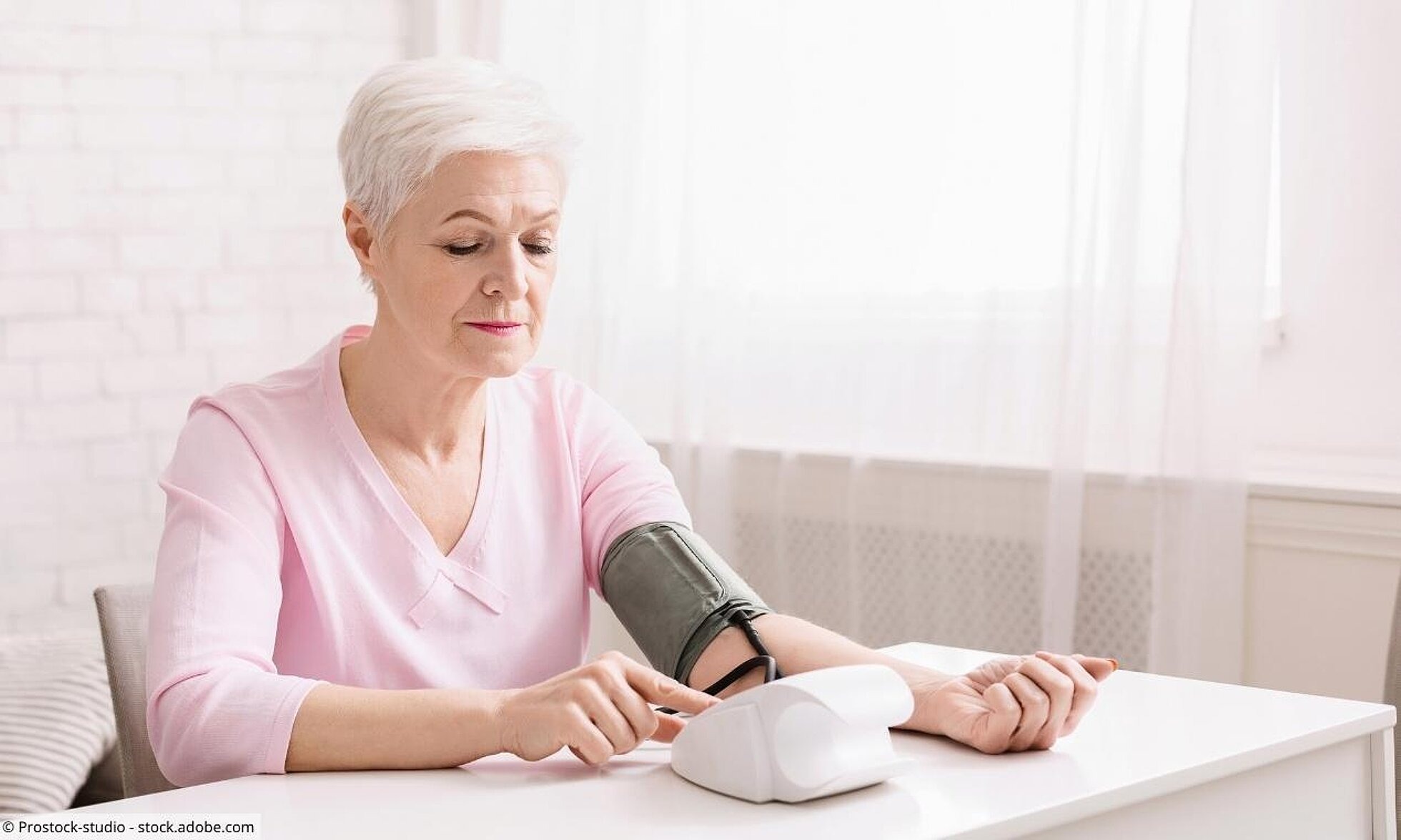 Ältere Frau misst Blutdruck