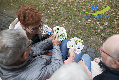 4 ältere Menschen spielen mit den Übungskarten der Bewegungspackung
