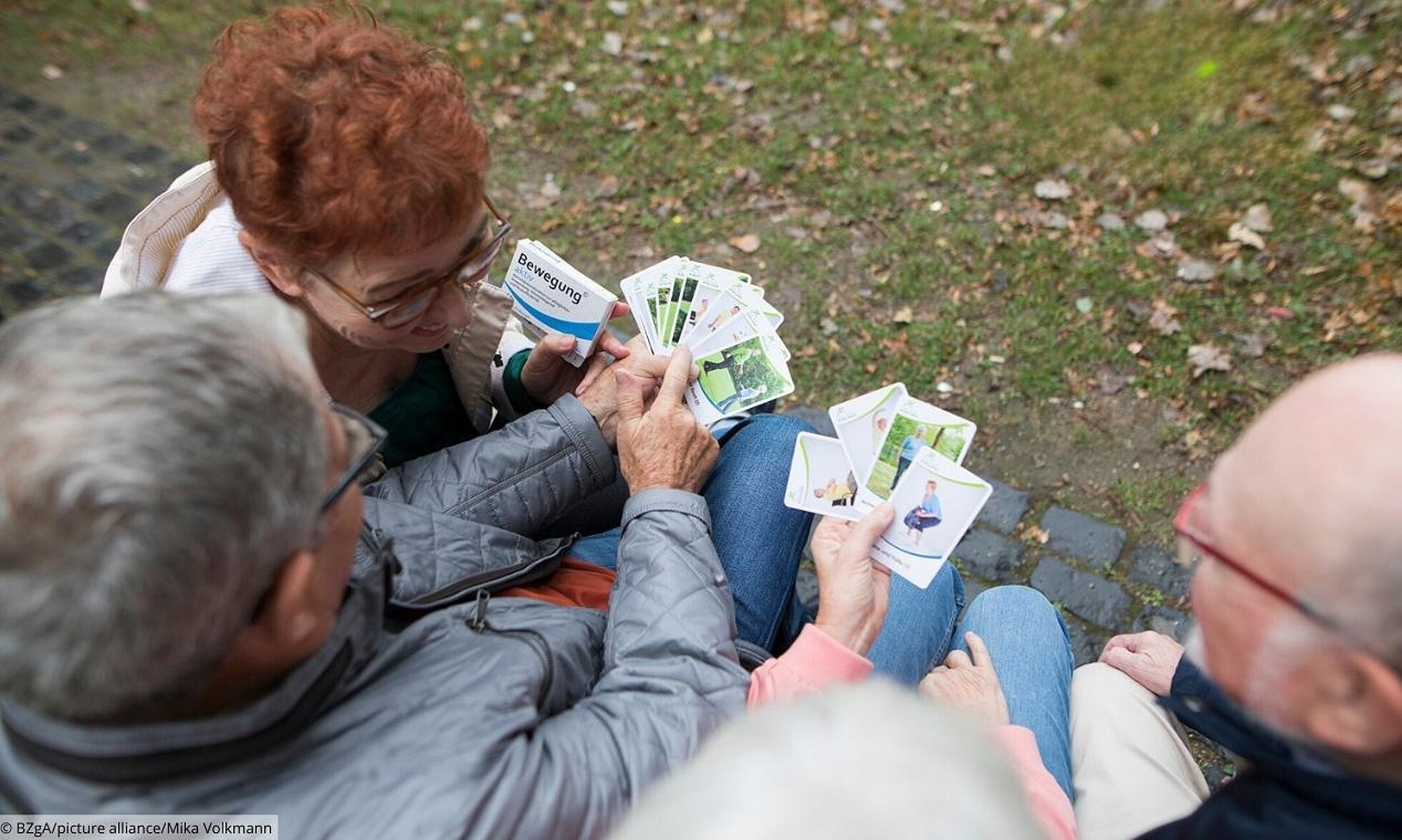 Gruppe älterer Menschen mit Karten der Bewegungspackung