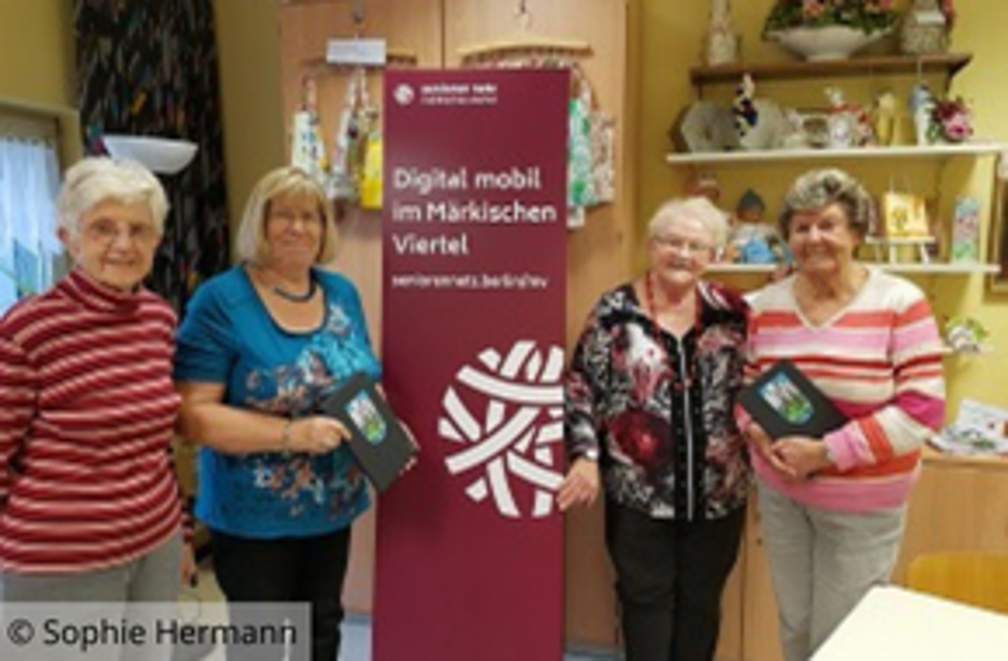 Evelyn Schmidt, Ursula Quanz, Sigrid Polenz, Ruth Schley stehen vor dem Banner von "SeniorenNetz - Digital mobil im Märkischen Viertel"
