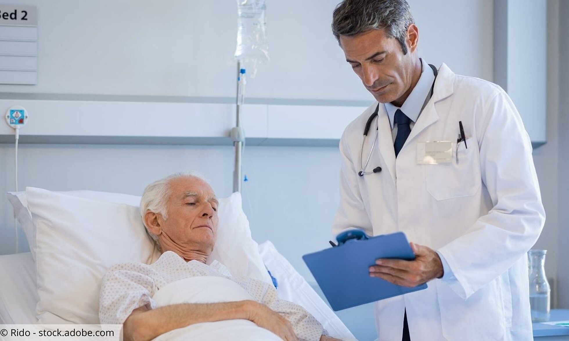 Arzt am Bett eines älteren Patienten