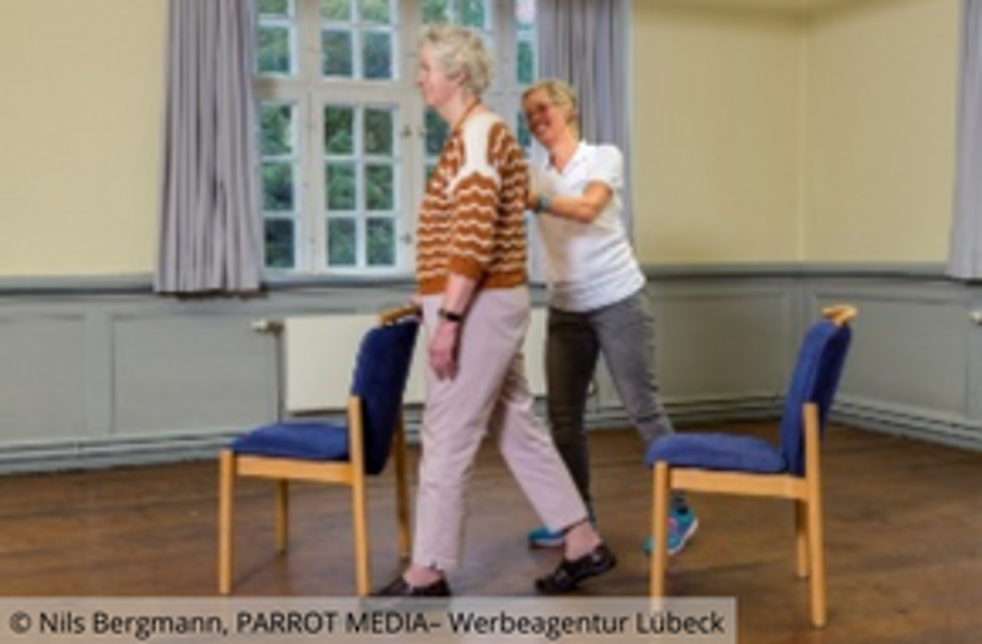 Ältere Frau und Trainerin beim Bewegungstraining