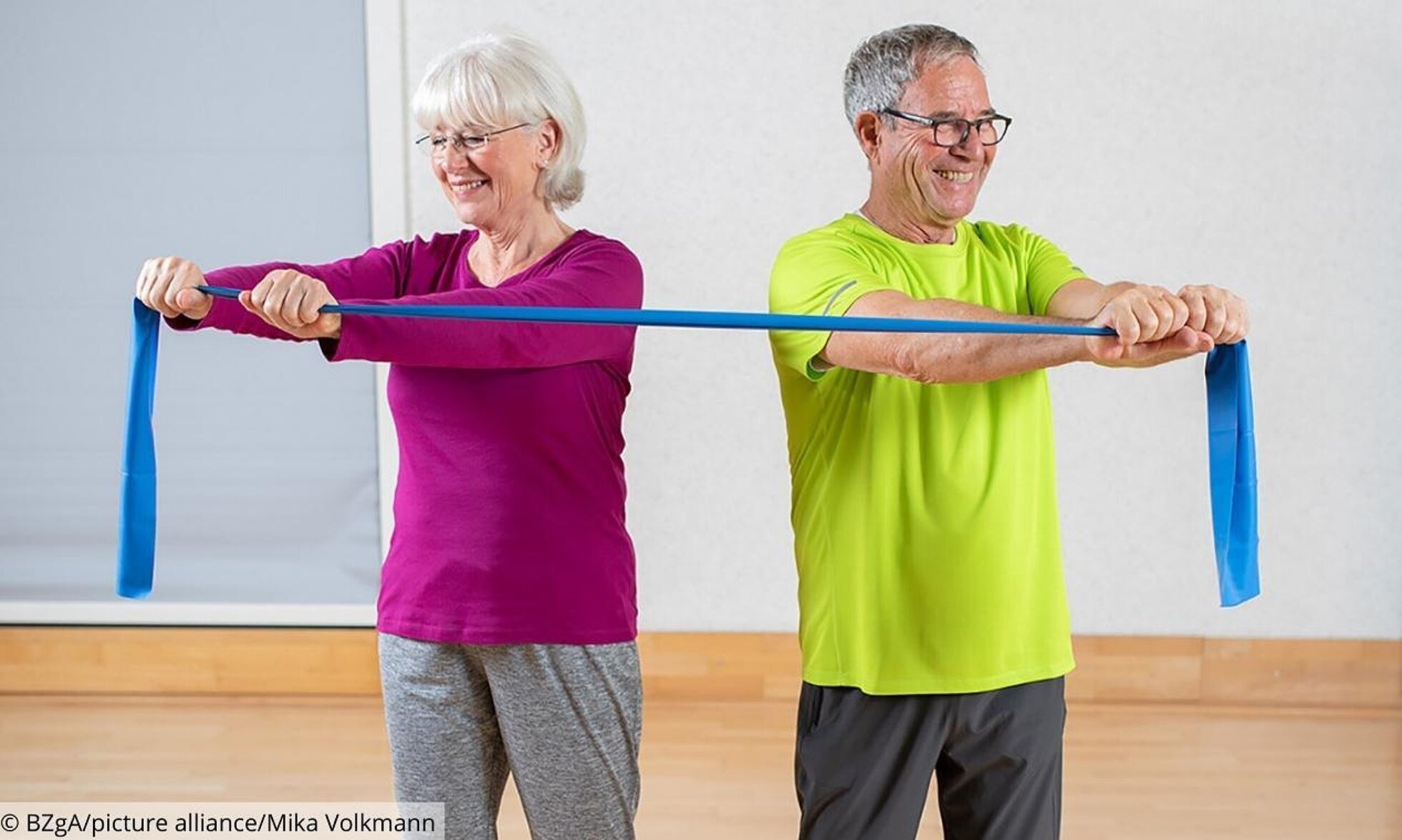 Mann und Frau teilen sich ein Fitnessband um Rumpf zu trainieren.
